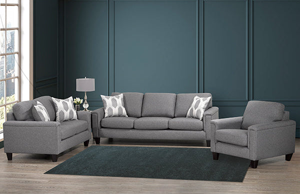 A 3-piece sofa set with gray upholstery, consisting of a sofa, loveseat, and chair, placed in a room with a dark blue wall and a light patterned rug.