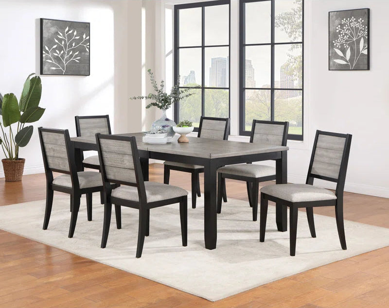 Dining room set with a table and six chairs in a well-lit room with large windows.