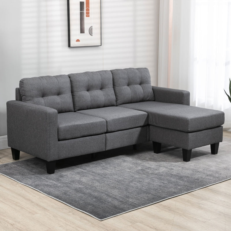 Gray sectional sofa in a living room setting with a rug and wall art.